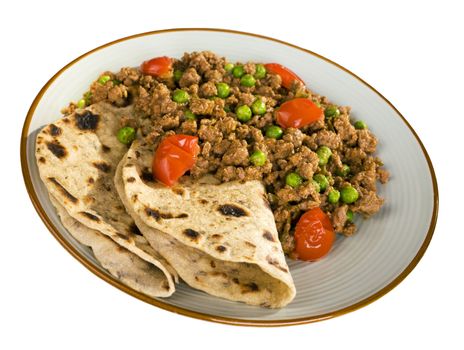 A plate of beef or lamb curry with peas and cherry tomatoes and chapatis, isolated on white, and with clipping path included. This is a lamb keema, made from minced or ground meat.