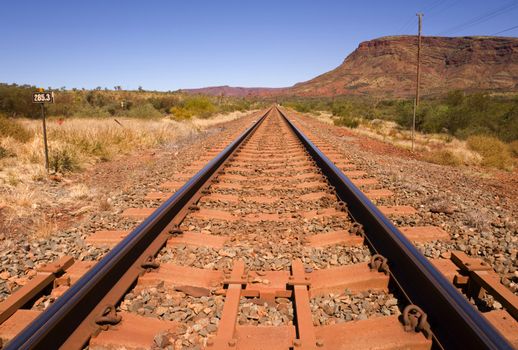Railway line running beside Mount Nameless near the town of Tom Price in Western Australia. Tom Price exists solely to support the mining of iron ore from this area of the Pilbara.