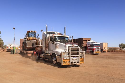 Trucking in Outback Australia - blue sky, red dirt and big rigs.