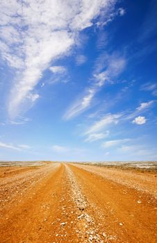 Red dirt road in the Australian outback, under a blazing hot blue sky..***INSPECTORS THIS IS NOT UPSIZED, IT IS TWO PHOTOS JOINED***