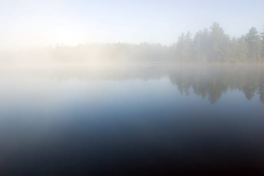 Fog above forest lake in Killarney Park in the morning