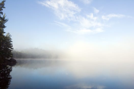 Fog above forest lake in Killarney Park in the morning