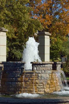 Fountain waterfall in sunlit on stone background