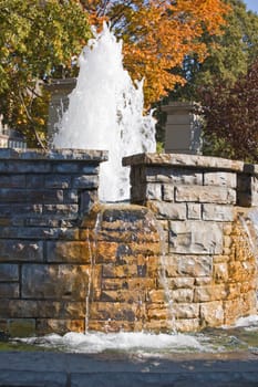 Fountain waterfall in sunlit on stone background