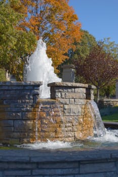Fountain waterfall in sunlit on stone background
