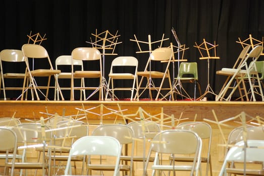 Music chairs and stands on stage for performers.