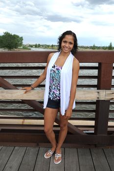 Fashion model posing on a bridge outside.