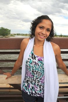 Fashion model posing on a bridge outside.