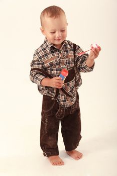 Bavarian boy in leather pants playing with soap bubbles