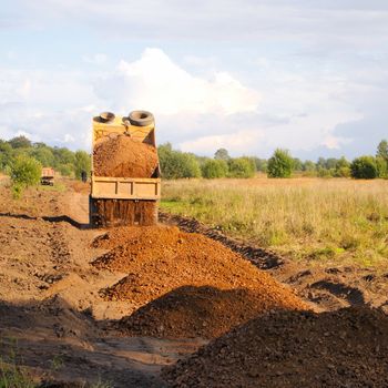 construction of roads, gravel truck unloads