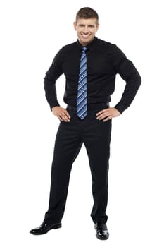 Casual portrait of handsome young businessman posing with hands on his waist