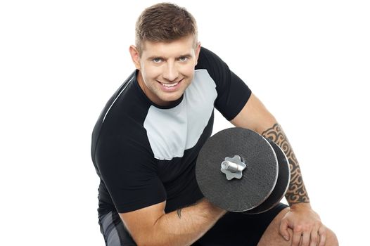 Muscular man working out with barbell isolated against white background