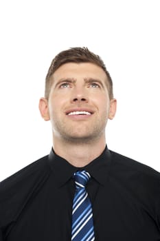 Smiling male executive looking upwards isolated over white background