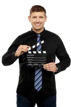 Young guy holding clapboard. Its showtime