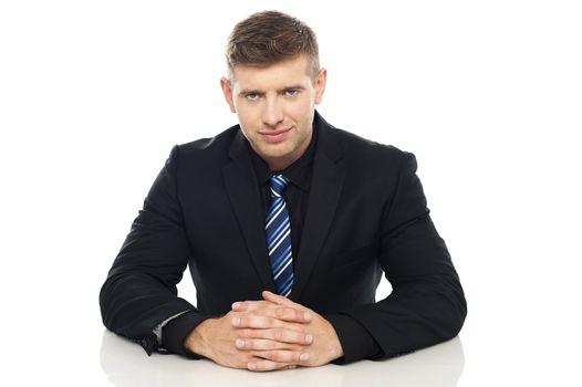 Smart young business executive at his work desk. Indoor studio shot