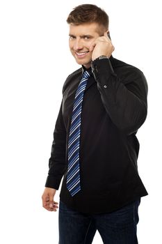 Cool young company CEO communicating via cellphone isolated against white