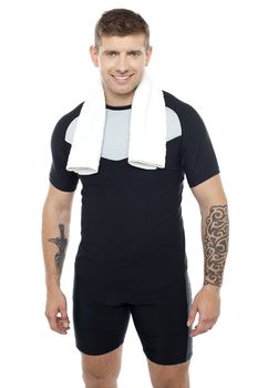 Young fit guy posing after gym workout. Tattoos on hands