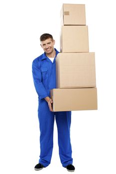 Full length portrait of delivery guy holding pile of cardboard boxes