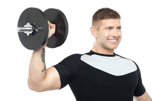 Muscular male showing his biceps by lifting heavy dumbbell. Looking away isolated against white