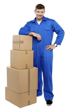 Relocation staff member in uniform resting against stack of cartons