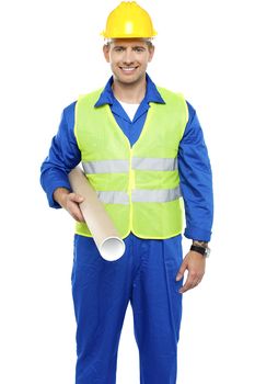 Experienced male architect carrying blueprints looking at camera