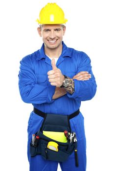 Smiling young industrial contractor showing thumbs up to camera