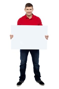 Handsome guy presenting blank billboard to camera isolated against white background