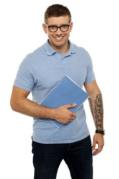 Modern college student holding notebook and posing against white background