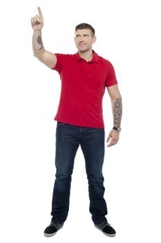 Full length shot of handsome guy pointing upwards