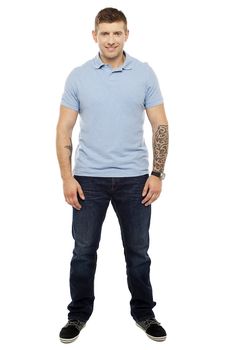 Smiling handsome man with tattoos in both the hands. Full length shot