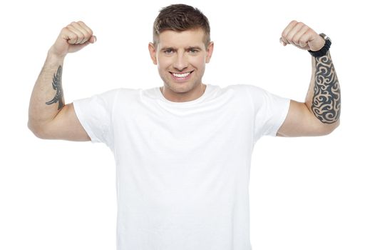Muscular handsome young man showing his biceps to you