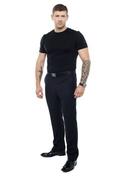 Strong male bouncer. Tattoo on both his hands. Full length shot