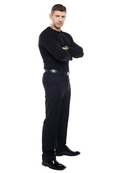 Handsome young bodyguard, full length portrait. Arms folded
