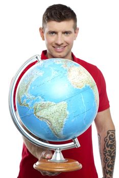 Guy with tattoos showing globe to camera isolated on white background