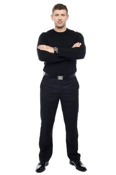 Young smart bouncer posing with his arms crossed isolated over white background.
