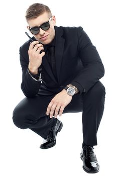 Handsome security officer investigating and communicating about the clue found on the floor