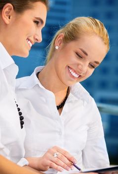 two happy businesswomen with papers (focus on blonde)