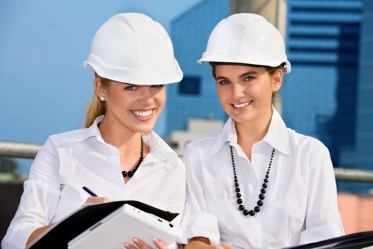 female contractors in a front of building site (focus on blonde)