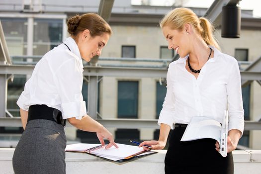 picture of two happy businesswomen with documents