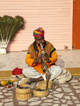 JAIPUR, INDIA - NOVEMBER 7 :Snake charmer shows his skill with the cobra to the tourists in front of the Hawa Mahal in Jaipur, Rajasthan, India on 7, Nov 2009.
