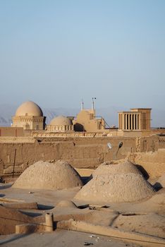 view of rooftops in yazd iran with desert mountains