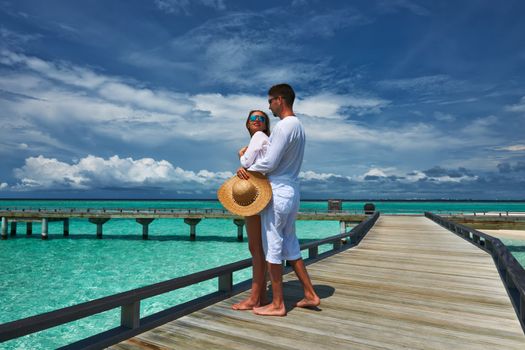 Couple on a tropical beach jetty at Maldives