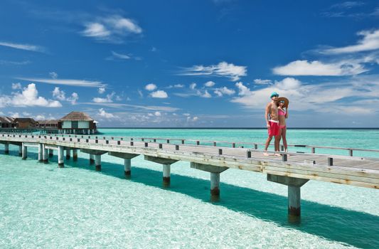 Couple on a tropical beach jetty at Maldives