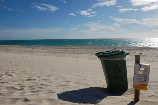 Rubbish bin on white sand beach, Perth, Australia