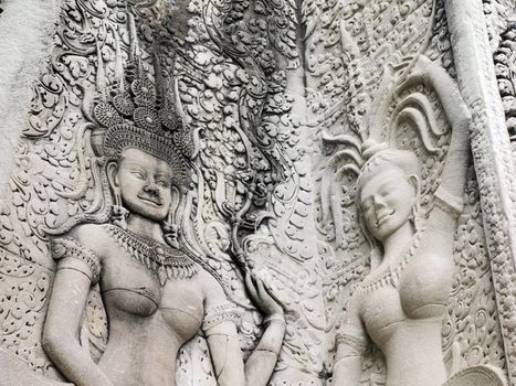 Details of sandstone carving of dancing Apsara on the wall of Angkor wat