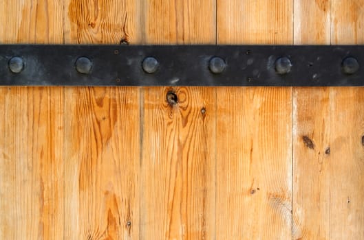 Detail of wooden door and black metal hinge