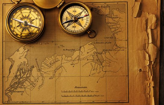 Antique brass compass over old map