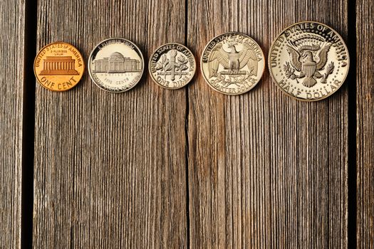 Five US cent coins over wooden background