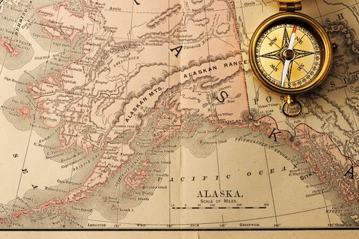 Antique brass compass over old XIX century map