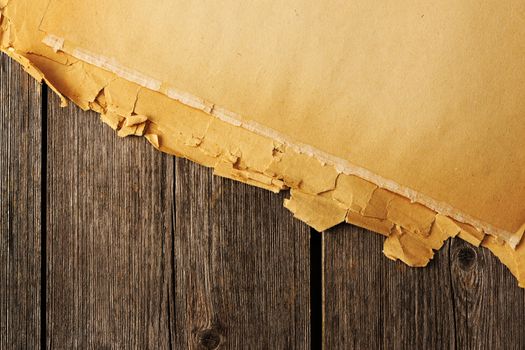 Old torn paper on wood planks background